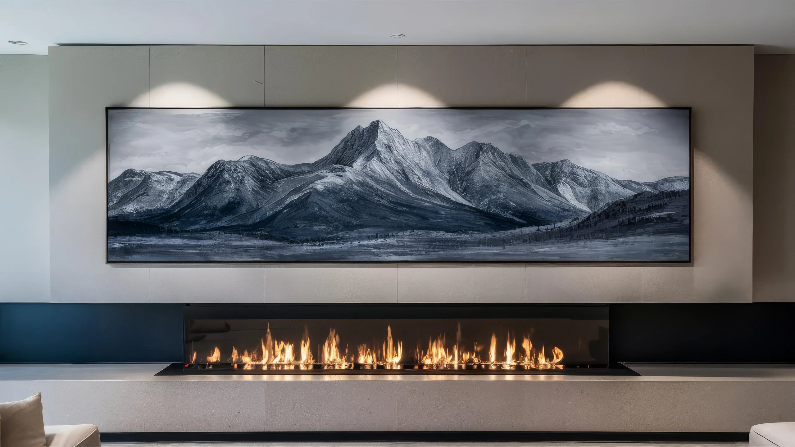 The image shows a dramatic panoramic landscape painting of snow-capped mountains against a moody, cloudy sky, displayed above a modern fireplace.