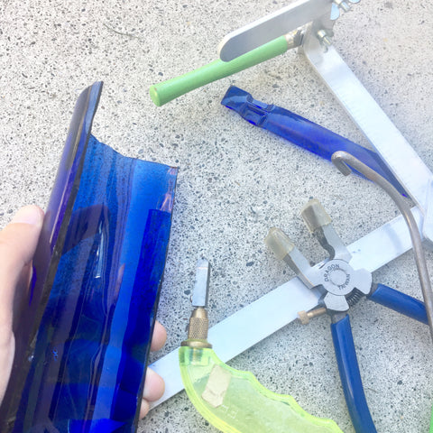 cutting a Skyy Vodka bottle into strips with glass cutting tools