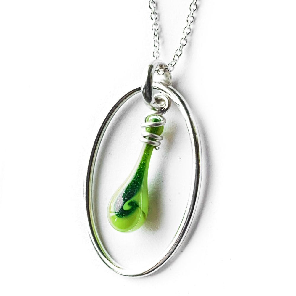 A swirl of dark glittering green adds to the striking lime green of this silver oval and glass teardrop necklace.