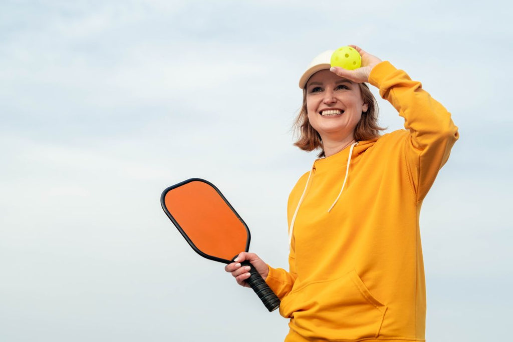 A pickleball player gets ready to serve the ball.