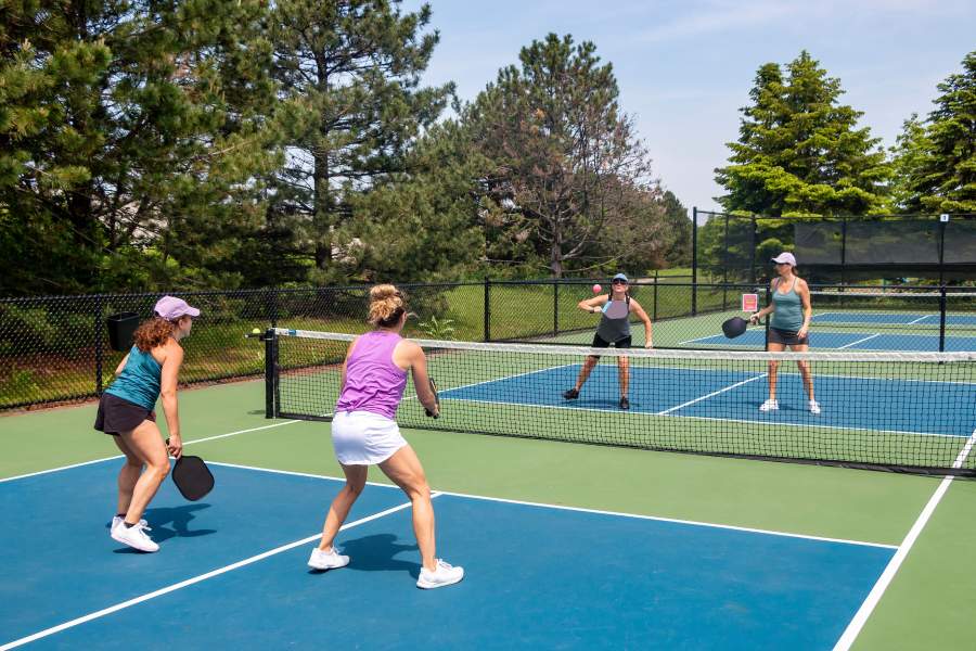 Four players in the midst of a pickleball doubles game