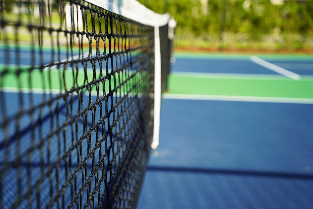 Looking down the centerline of a pickleball court, with the net prominently featured.