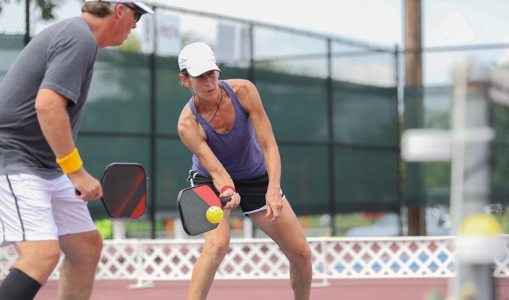 aged couple playing pickleball