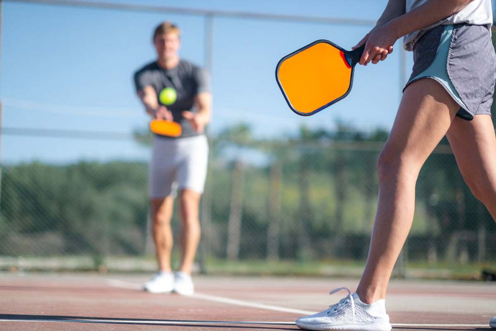 Pickleball players practice before a match.
