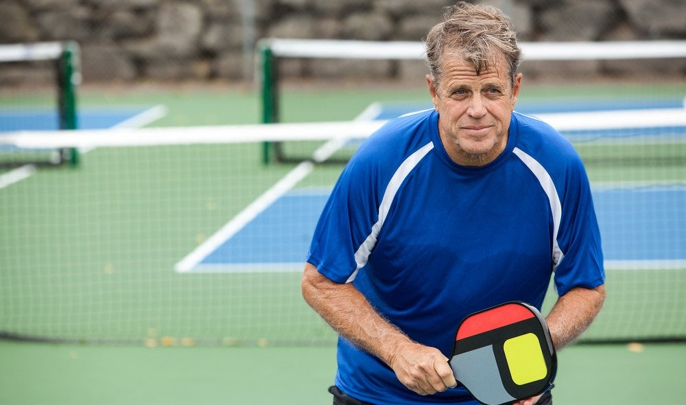 old man plying pickleball