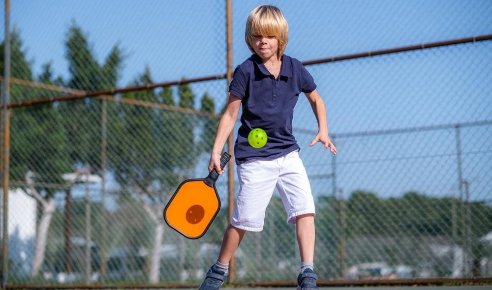 teen boy playing pickleball