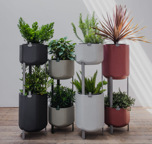 Collection of self-watering planters stacked to form indoor garden