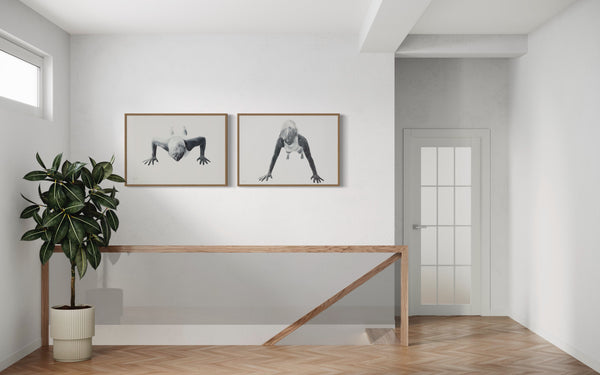 Hallway with white walls, wooden floors and a wood staircase. On the wall there are two prints with wood frames from Jenny Mørk.