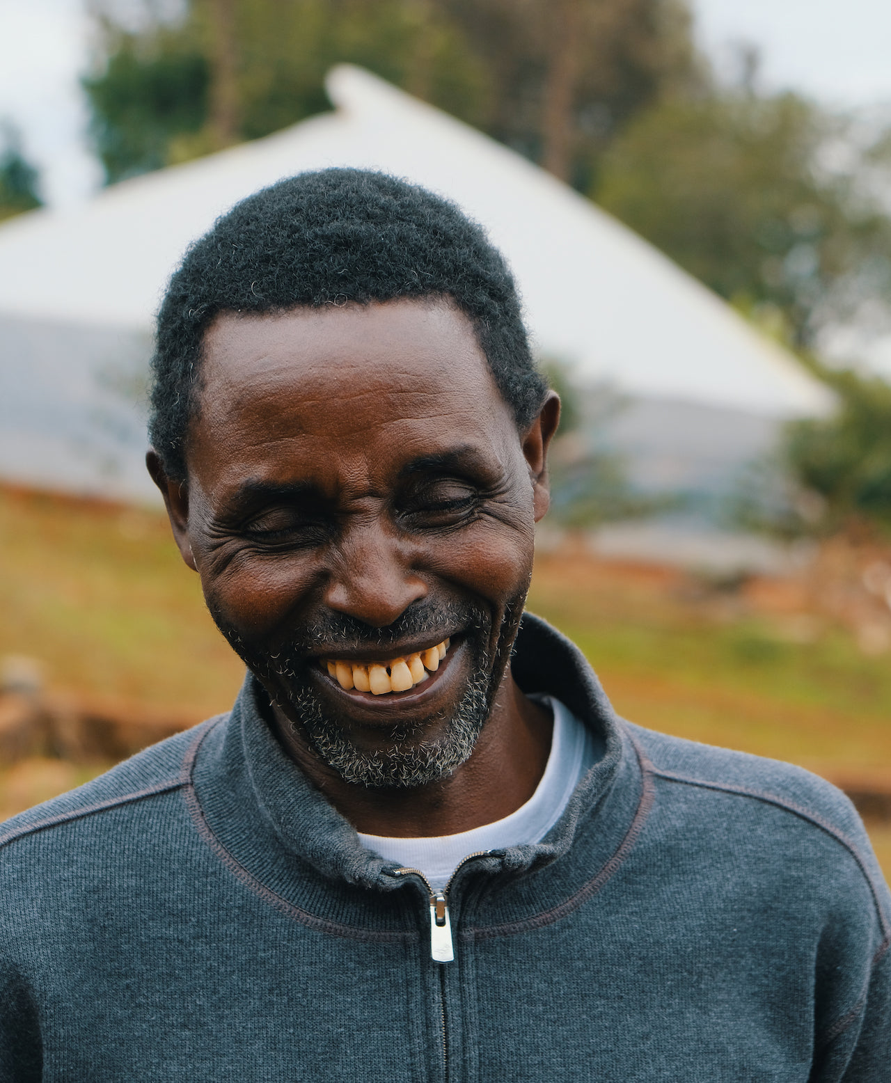 Gentleman smiling and looking down at coffee farm.