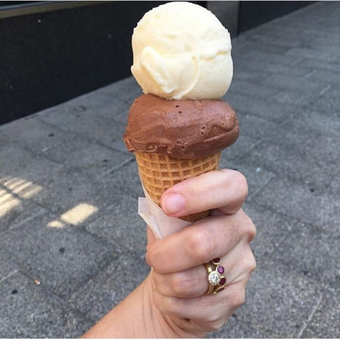 Ruby ring and diamond ring on hand holding ice cream cone