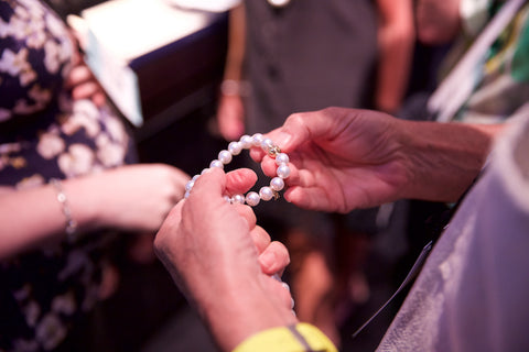 inspecting a pearl bracelet up close