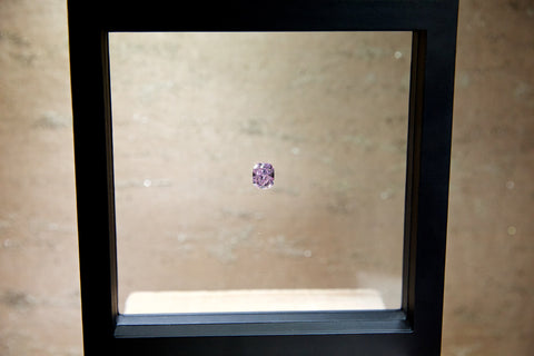 natural fancy intense purple pink diamond in a display