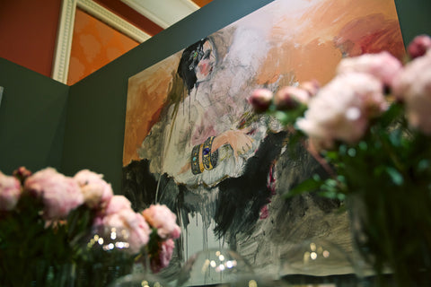 Painting on the wall of the Arman booth with flowers in front