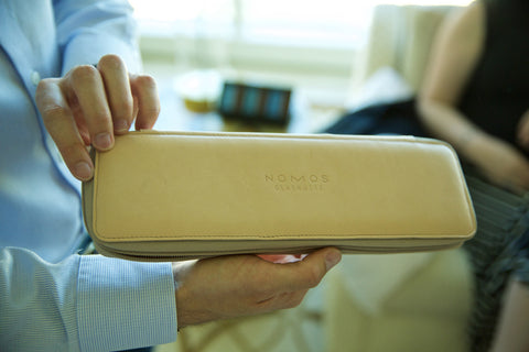 Photo of a man holding the new Nomos cream colored watch case.