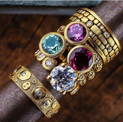 Alex Sepkus 18k yellow gold rings with diamonds and colored stones on a mandrel