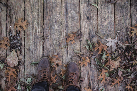 boots on wooden leafy deck