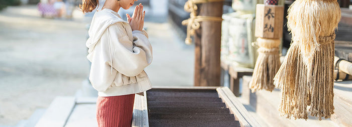 神社にお参りしている人の画像