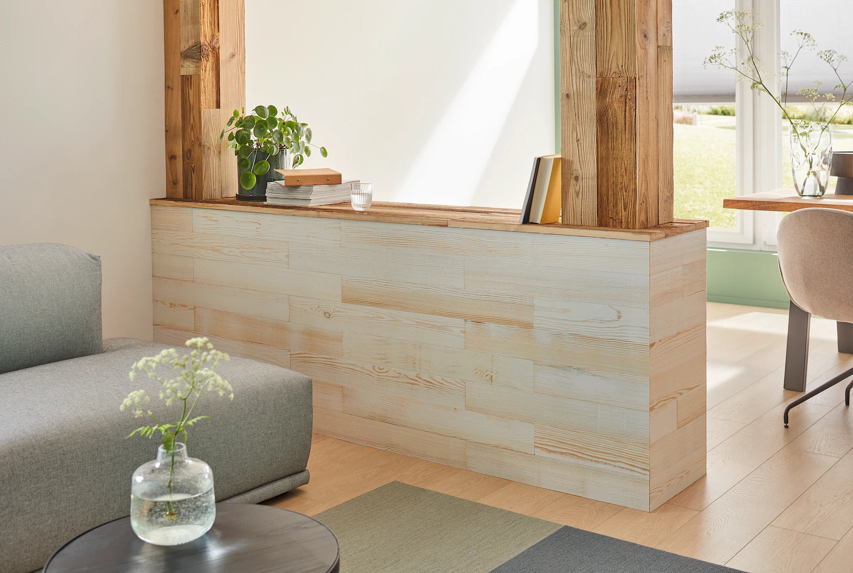 Nahaufnahme einer Trennwand im Wohnzimmer aus Holzpaneelen “White” und Altholzbrettern
