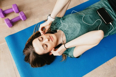 women listening music and resting out on gym floor