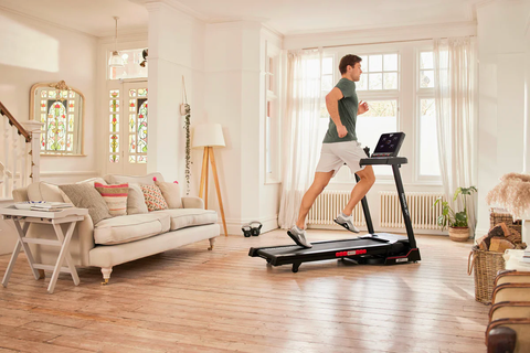 Man running on a treadmill in a white themed living hall