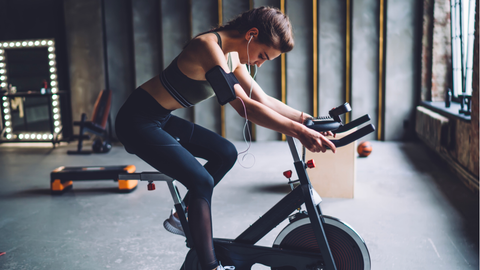 Muscular lady working out using cycle indoors