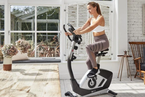 woman working out on exercise bike in garden area