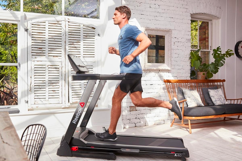 man jogging in a treadmill placed in the living room