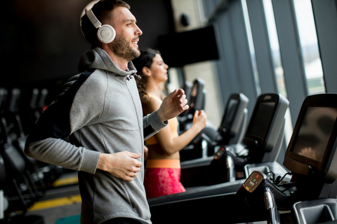 Man with headphones running on treadmill