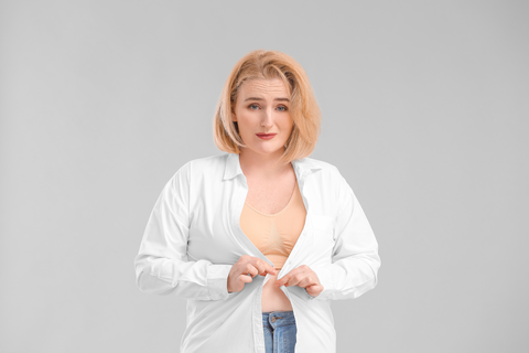 woman trying to button shirt
