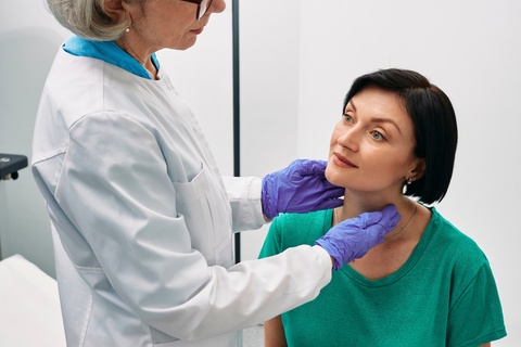 woman getting thyroid checked by doctor