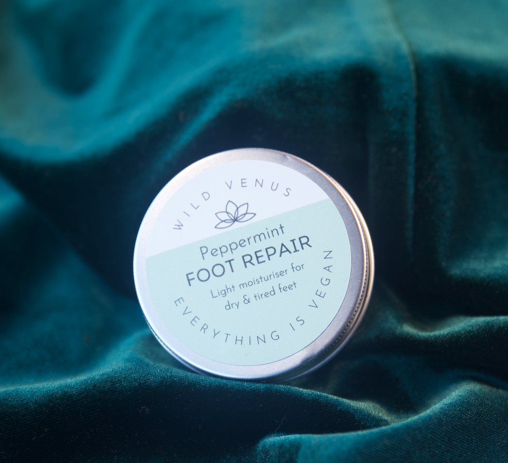 rosemary foot sooth body butter in a tin on velvet.