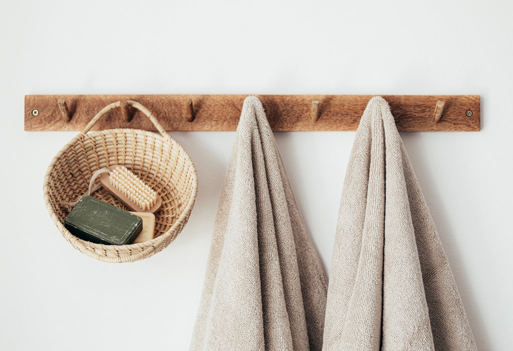 Hanging rack with towels and a basket of shower sundries.