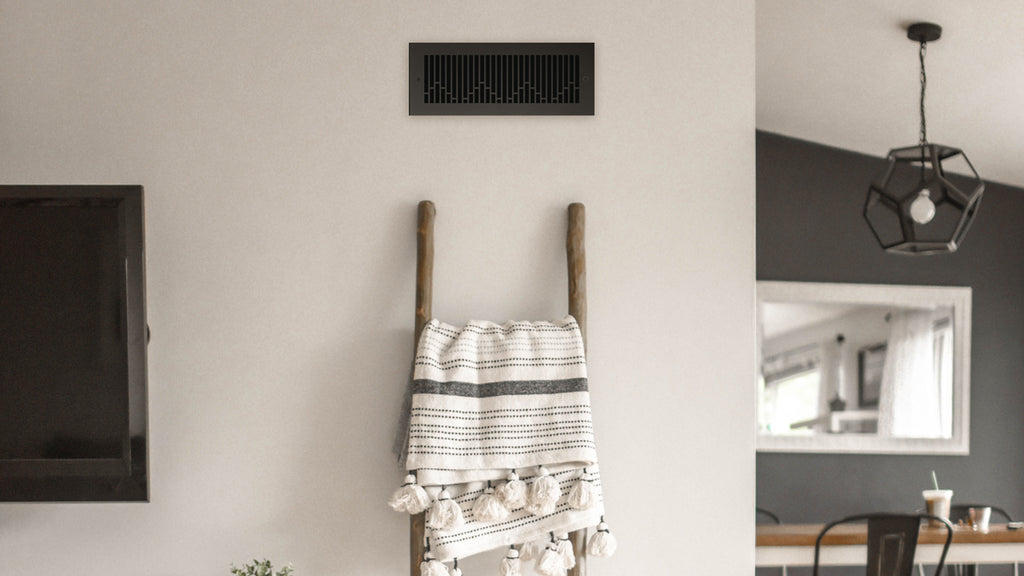 Neutral open format living space with black register in the wall near the ceiling.