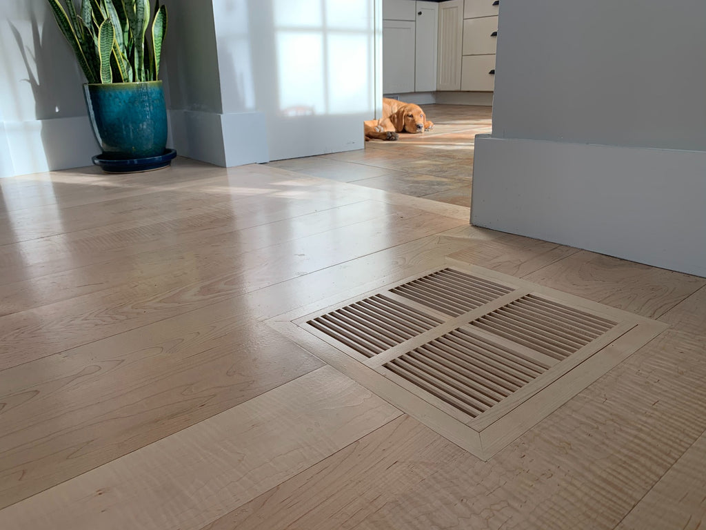 Wood vent cover in a wood floor flush mounted for a smooth surface.