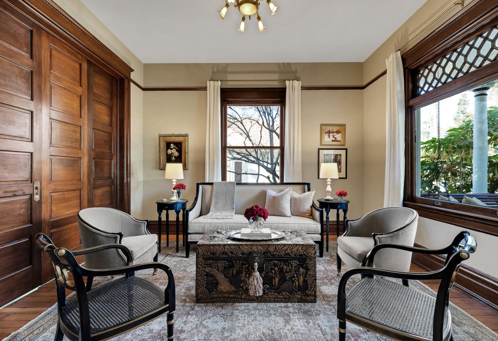 Large living room in the Victorian style with club chairs and dark wood accents.