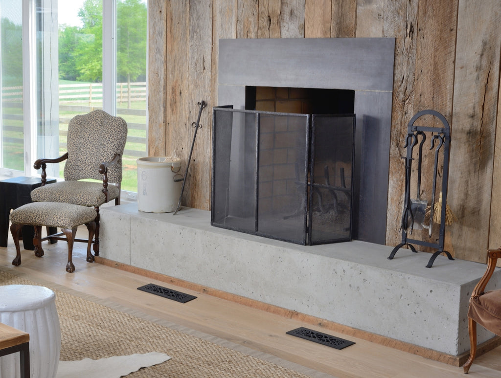 Two register covers in front of a living room fireplace