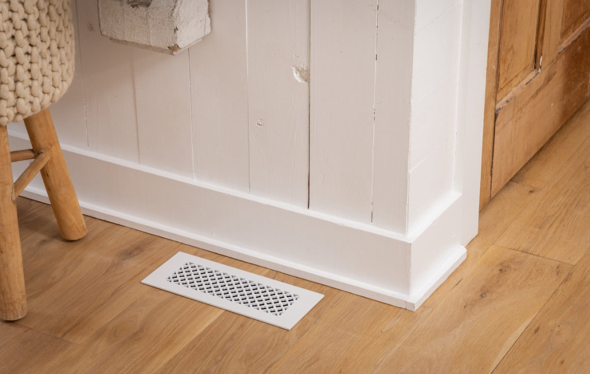 White register in a wood floor with white walls.