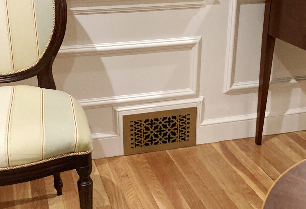 Vintage grille installed in a wall near a wood floor.