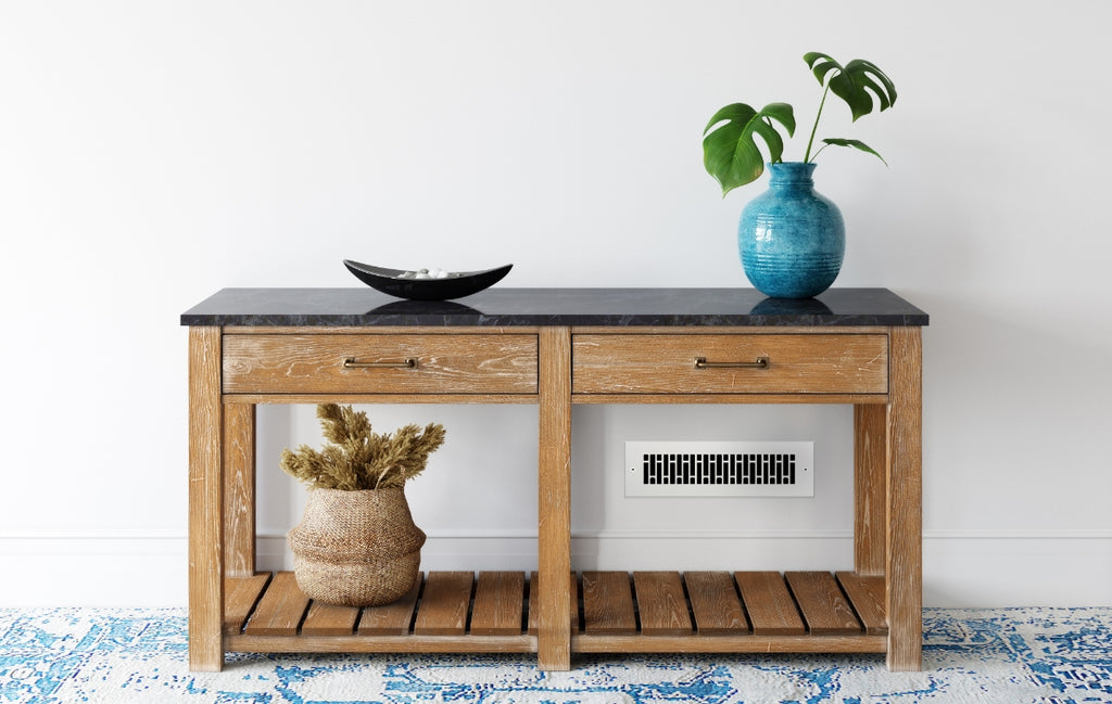 White room with wood console and blue rug with silver register in the wall.