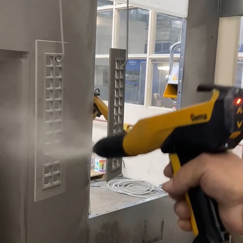 Person spraying powder coating on a register.