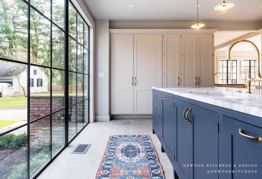 Galley kitchen with blue cabinets and oriental rug