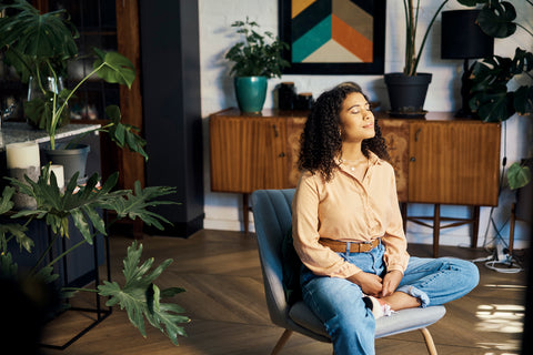 Woman sitting in living room happy mindset. Mindfulness houseplants.