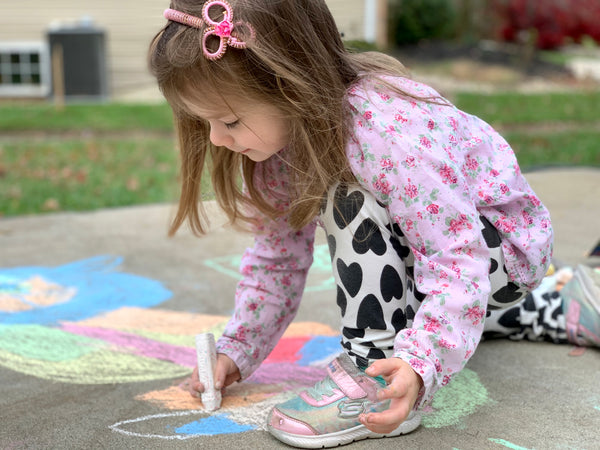 Girl drawing with chalk outside