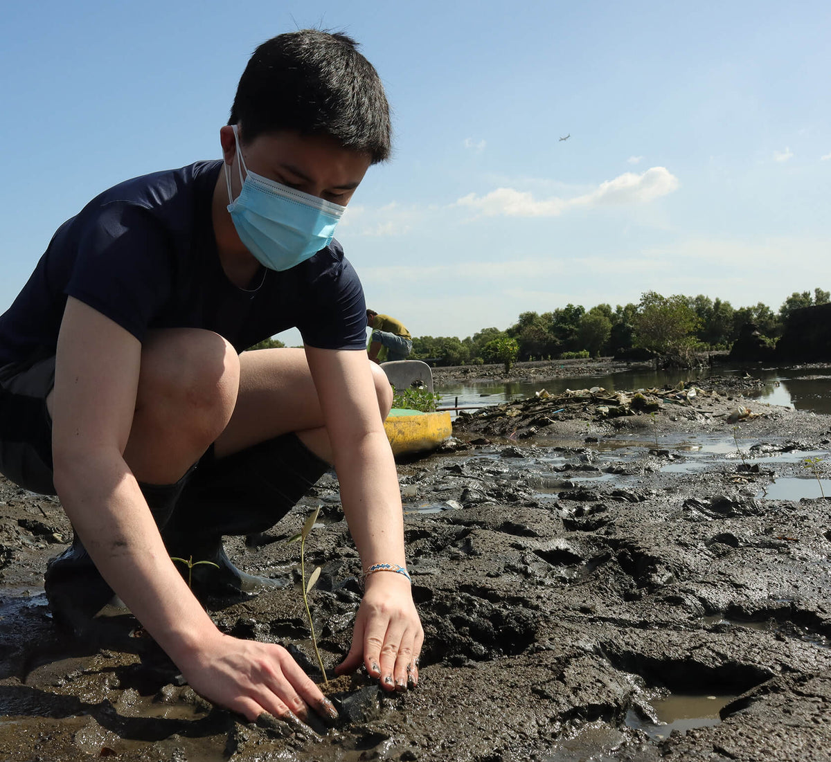 Founder Tyler Uy planting his first mangrove tree