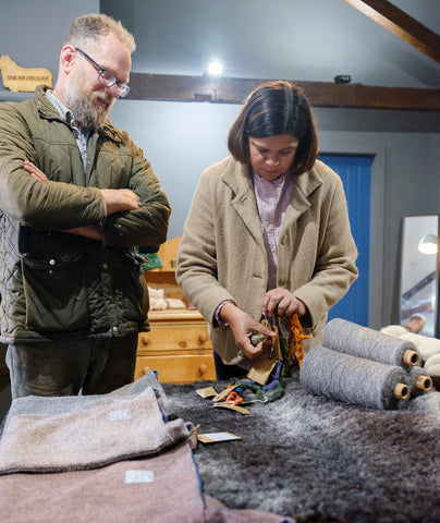 John Atkinson and Maria Benjamin looking at yarn samples and wool products