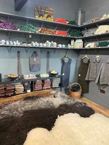 Farm shop with sheepskins, tweed jackets, knitting wool and soap on display