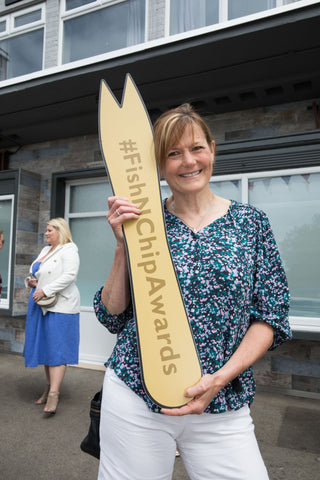 Sarah Heward from The Real Food Cafe in Tyndrum at the launch of National Fish & Chip Awards 2024 holding a big wooden fork prop