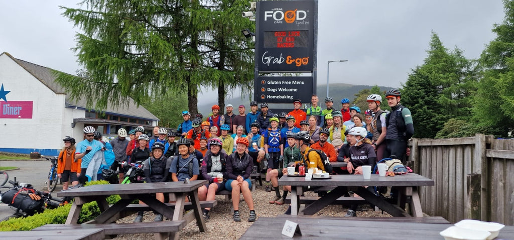 A group of Highland Trail 550 bike packing  racers outside The Real Food Cafe in Tyndrum