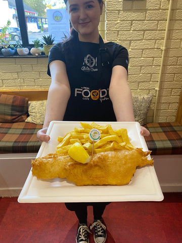 Imogen Atkinson at the real food cafe holding gluten free fish n chips top 10 young fish frier of the year 2024
