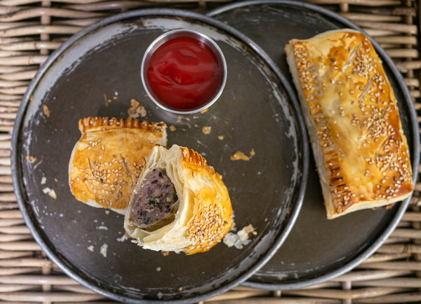 Haggis and black pudding sausage roll cut in half served at the real food cafe with spicy ketchup